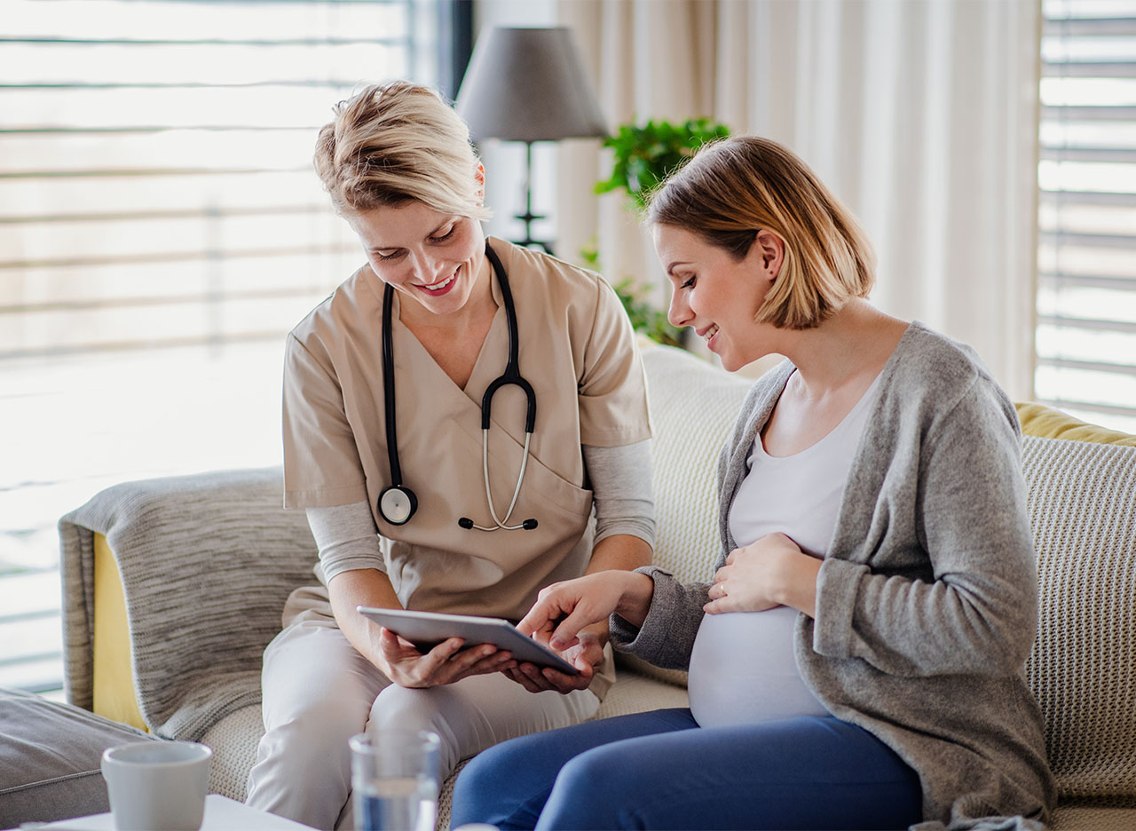 Pregnant woman reviewing records with clinician